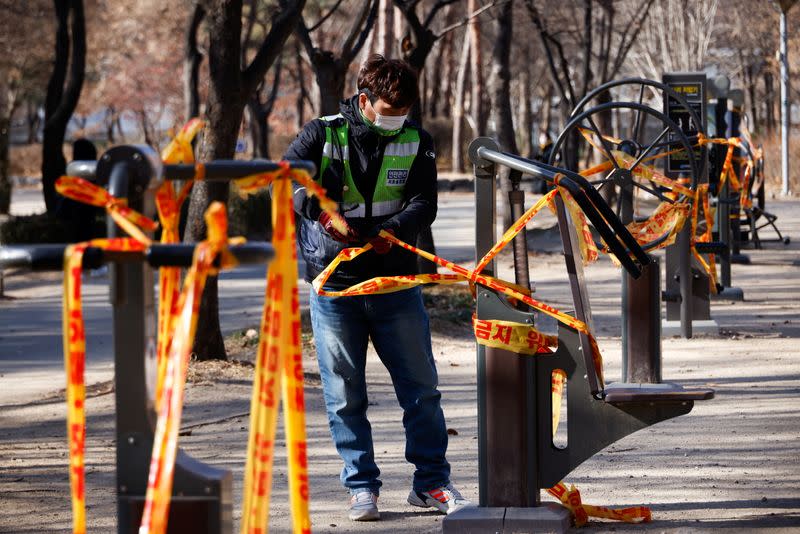 An employee cordons an outdoor gym off as part of a measure to avoid the spread of the coronavirus disease (COVID-19) at a park in Seoul