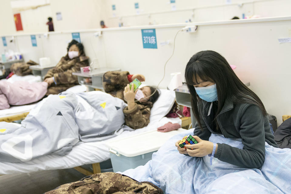 A patient solves a Rubik's cube at a temporary hospital converted from "Wuhan Livingroom" in Wuhan, central China's Hubei Province, Feb. 10, 2020. (Photo: Xinhua News Agency via Getty Images)