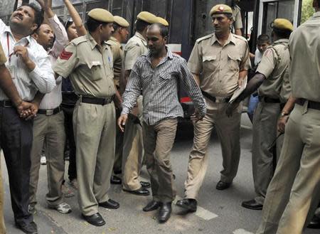 Mukesh Singh (C), one of the four men who were sentenced to death for the rape and murder of a young woman on a bus last December, is escorted by police outside a court in New Delhi September 24, 2013. REUTERS/Stringer/Files