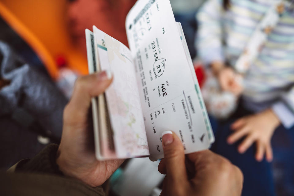 A hand holding travel documents.