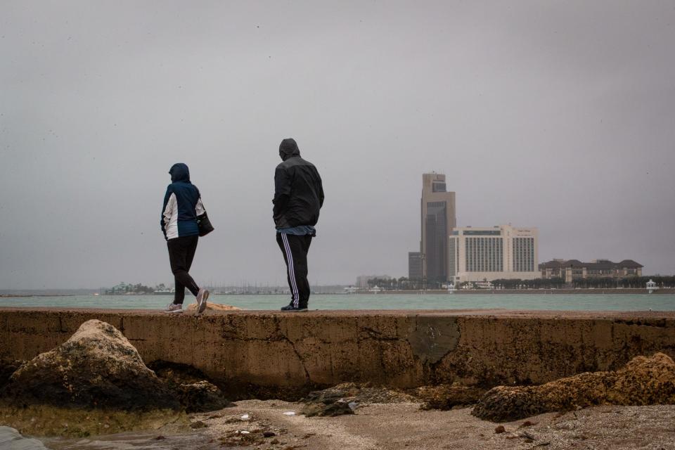 People walk along the jetty on North Beach after rain pelted the area on Wednesday, Jan. 24, 2024, in Corpus Christi, Texas.