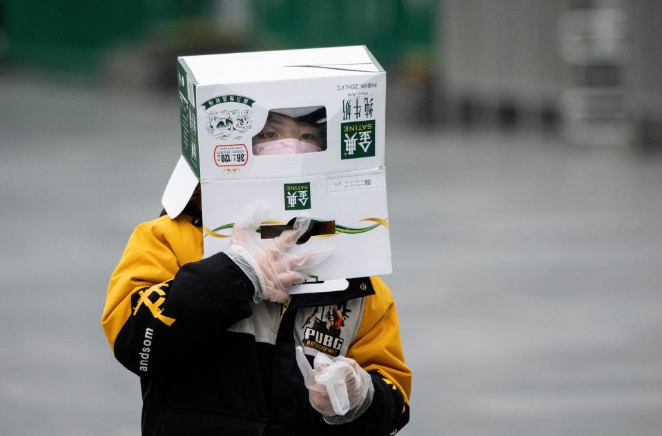 A boy wears a cardboard box on his head at the Shanghai Railway station in Shanghai on February 13, 2020. - The number of deaths and new cases from China's COVID-19 coronavirus outbreak spiked dramatically on February 13 after authorities changed the way they count infections in a move that will likely fuel speculation that the severity of the outbreak has been under-reported. (Photo by NOEL CELIS / AFP) (Photo by NOEL CELIS/AFP via Getty Images)