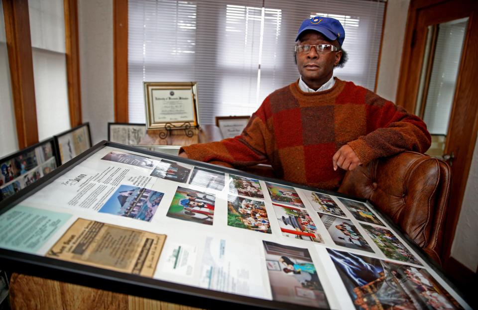 Ken Swan with photos from past Walt Disney World trips with teens that worked for his lawn maintenance business.  Swan gave David Crowley his first job.