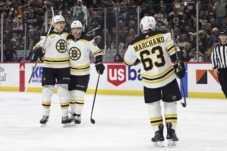 Boston Bruins right wing David Pastrnak (88) celebrates with defenseman Hampus Lindholm (27) after Pastrnak scored a goal during the second period of an NHL hockey game Sunday, March 18, 2023, in St. Paul, Minn. Boston won 5-2. (AP Photo/Stacy Bengs)