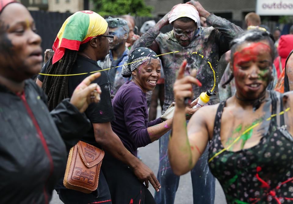 <p>Revellers dance and spray paint, a traditional way of starting the carnival on the first day of the Notting Hill Carnival in west London on August 28, 2016. (Photo: DANIEL LEAL-OLIVAS/AFP/Getty Images) </p>