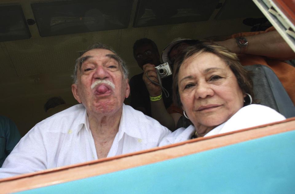 FILE - In this May 30, 2007 file photo, Colombia's Literature Nobel Prize winner Gabriel Garcia Marquez sticks out his tongue to photographers as he arrives on a train to Aracataca, his hometown in northeastern Colombia. At right is his wife Mercedes Barcha who accompanied the writer on his first visit to his hometown in 25 years. Marquez died Thursday April 17, 2014 at his home in Mexico City. Garcia Marquez's magical realist novels and short stories exposed tens of millions of readers to Latin America's passion, superstition, violence and inequality. (AP Photo/William Fernando Martinez, File)