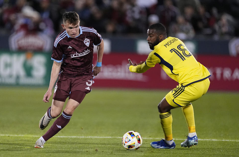 Colorado Rapids defender Sam Vines, left, pursues the ball with Nashville SC defender Shaq Moore, right, during the first half of an MLS soccer match Saturday, March 2, 2024, in Commerce City, Colo. (AP Photo/David Zalubowski)
