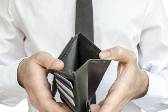 Man in white shirt and black tie holding an empty wallet.