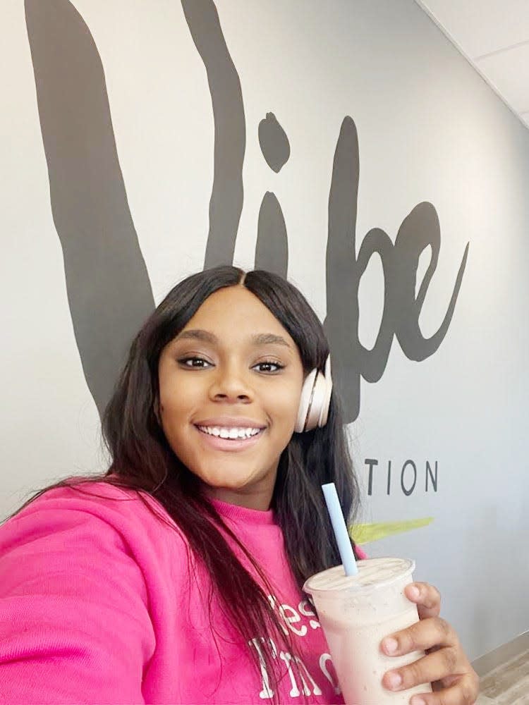 The author wearing headphones and drinking a shake at Vibe.