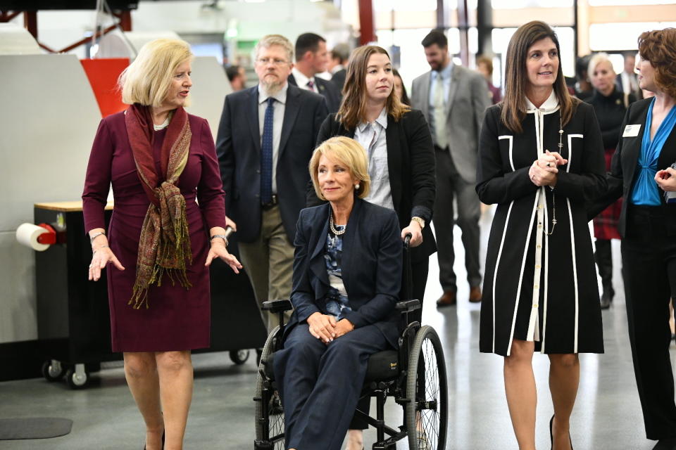 U.S. Secretary of Education Betsy DeVos, seated, tours a technical college in Florence, S.C., Thursday, Feb. 21, 2019, with state Education Superintendent Molly Spearman, left, and Lt. Gov. Pamela Evette, right. DeVos made a trip to the state to visit an area once known as the “Corridor of Shame” where officials say dramatic improvements have been made in schools since state officials took over their control last year. (AP Photo/Meg Kinnard)