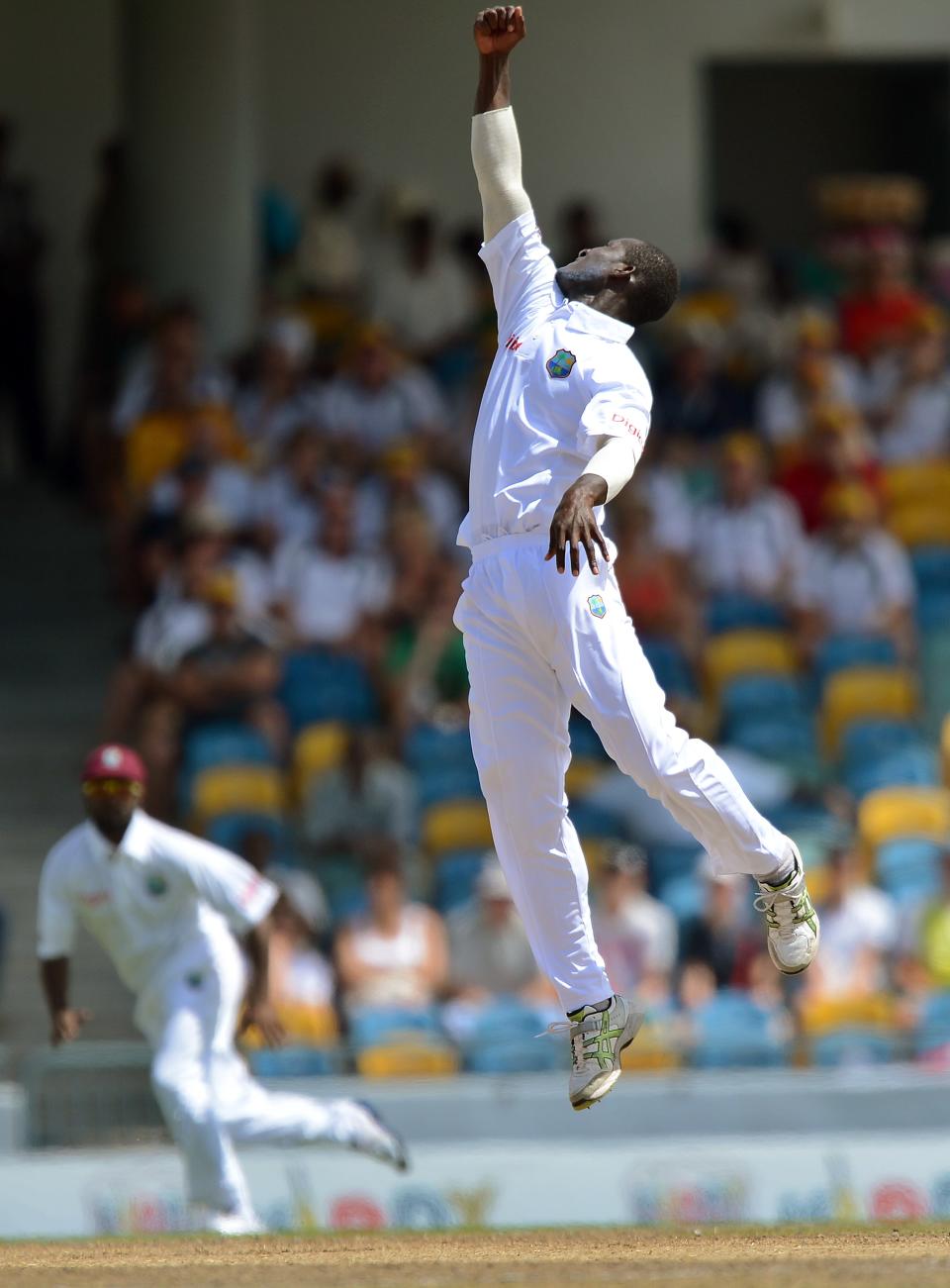 West Indies cricket team captain Darren Sammy (R) leaps in the air to field a ball during the third day of the first-of-three Test matches between Australia and West Indies at the Kensington Oval stadium in Bridgetown on April 9, 2012. West Indies scored of 449/9 at the end of their first innings. AFP PHOTO/Jewel Samad (Photo credit should read JEWEL SAMAD/AFP/Getty Images)