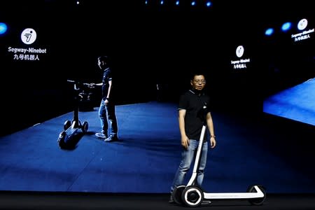 Ninebot President Wang Ye unveils semi-autonomous scooter KickScooter T60 that can return itself to charging stations without a driver, at a Segway-Ninebot product launch event in Beijing