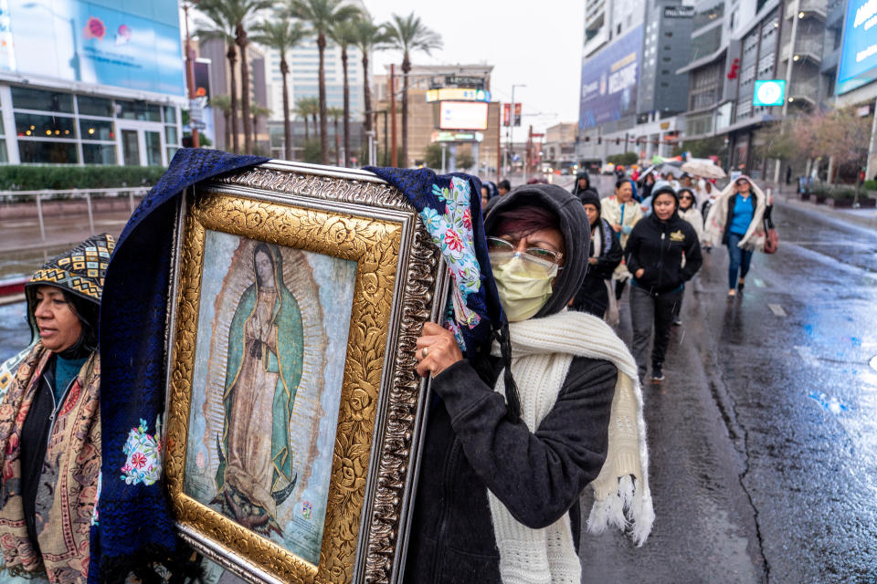 Elena Sebastian, left, and Rocio Perez, right, carry a painting of the Virgin Mary during a procession organized by the Phoenix Catholic Diocese celebrating the feast day of Our Lady of Guadalupe in Phoenix on Dec. 3, 2022.