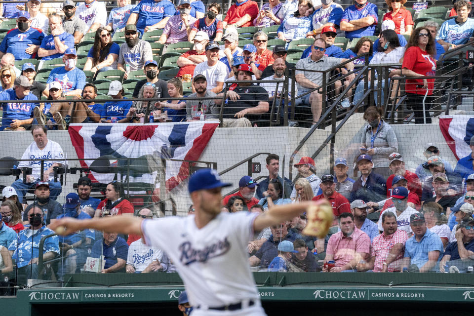 Texas Rangers fans watch relief pitcher Kyle Cody work against the Toronto Blue Jays during the seventh inning of a baseball game Monday, April 5, 2021, in Arlington, Texas. (AP Photo/Jeffrey McWhorter)