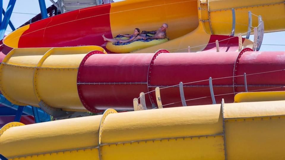 People ride a water slide.