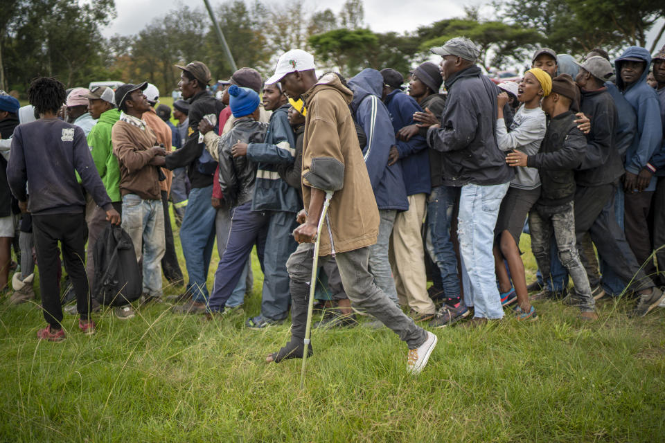 Homeless recyclers and other destitute people, some of whom said they have not eaten in three days, lineup in a Johannesburg park, waiting to receive food baskets from private donors, Thursday, April 9, 2020. Because of South Africa's imposed lockdown to contain the spread of COVID-19, many people who don't have savings and are unable to work are not able to buy food. (AP Photo/Jerome Delay)