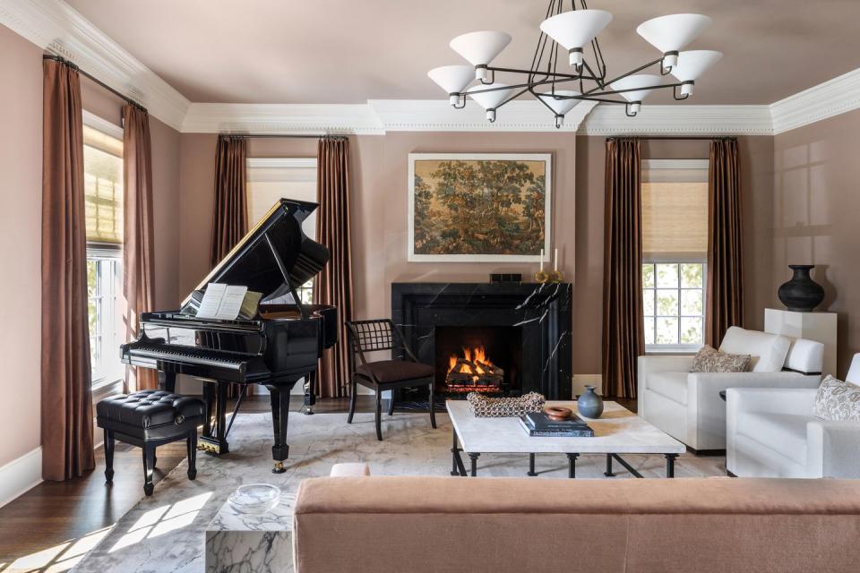 a living room with a piano and a fireplace