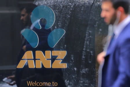 A pedestrian is reflected in the window of a branch of the Australia and New Zealand Banking Group (ANZ) in central Sydney