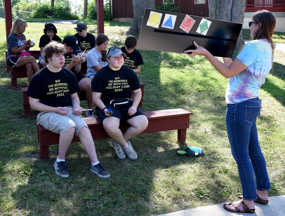 Music Therapist Kate Holsopple-Stainbrook of Toledo points to a key note chart for the campers to play a Star Wars song on their xylophone bars at Holiday Camp.