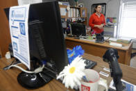 FILE - In this Aug. 22, 2019, file photo, Library Director Jennifer Ramirez advises a visitor that she is unable to assist him with his request because most of the computers at the public library in Wilmer, Texas, were not working. The Associated Press has learned new details about a ransomware attack that affected roughly two dozen Texas communities two years ago. Thousands of pages obtained by AP and interviews with people involved show Texas communities struggled for days with disruptions to core government services as workers in small cities and towns endured a cascade of frustrations brought on by the sophisticated cyberattack. (AP Photo/Tony Gutierrez, File)