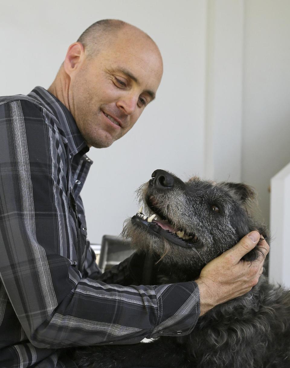 Martin Sprouse with 'Grady', an Airedale Terrier-Irish Wolfhound mix, Thursday, April 18, 2013, in Oakland, Calif. After his owner brought the dog to the Kauai Humane Society because he was moving, the dog with the big brown eyes languished for four months, said shelter operations manager Brandy Varvel. But now Grady is living in a spacious California loft with a new owner who is admittedly smitten thanks to an arrangement the Kauai Humane Society has with the East Bay SPCA in Oakland. The Kauai Humane Society has been reaching out since December to Hawaii tourists willing to bring a little extra baggage, one of the island’s many strays and abandoned dogs, when returning to the Bay Area. The dogs are mostly mixed breeds derived from Airedales, whippets and hounds; breeds which are used in the Hawaii Islands to hunt feral pigs. (AP Photo/Ben Margot)