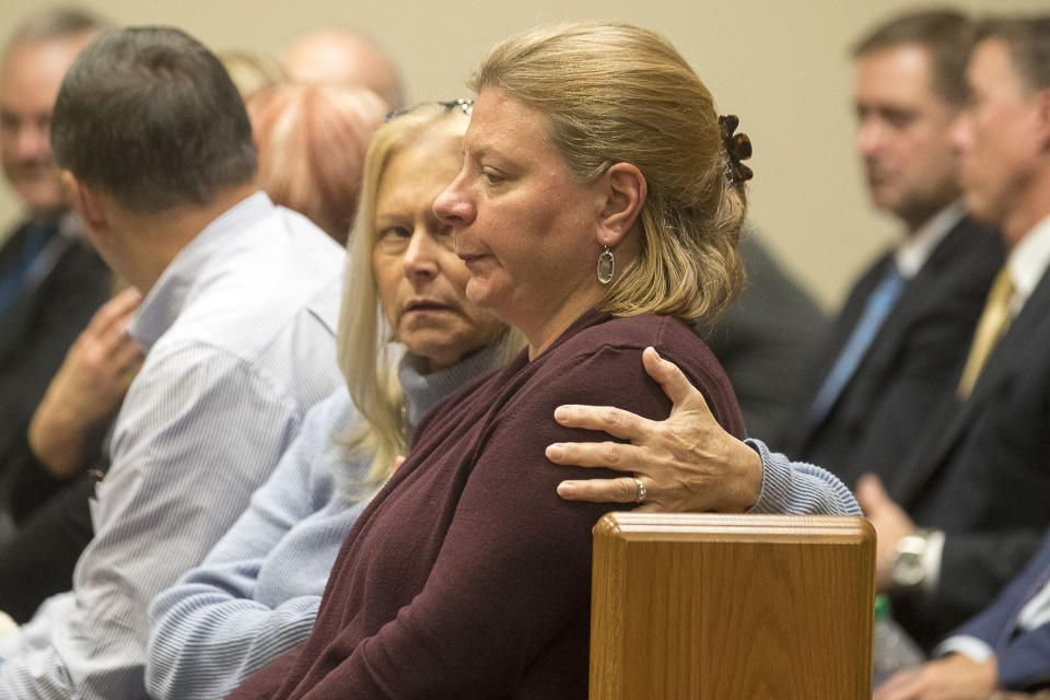 Katherine Olsen, right, wife of former DeKalb County Police officer Robert Olsen, is consoled after his sentencing, Friday, Nov. 1, 2019, in Decatur, Ga. Olsen, who was convicted of aggravated assault and other crimes in the fatal shooting of an unarmed, naked man, was sentenced Friday to 12 years in prison.. (Alyssa Pointer/Atlanta Journal-Constitution via AP)