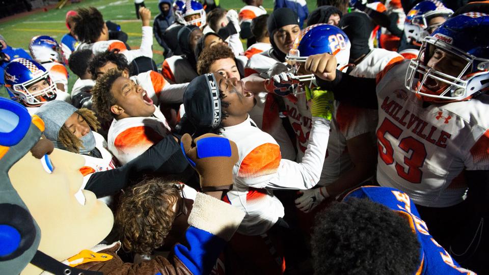 Members of the Millville High School football team celebrate their 18-14 victory over Mainland in the state Group 4 semifinal football game played at Cherokee High School in Marlton on Sunday, November 20, 2022.  