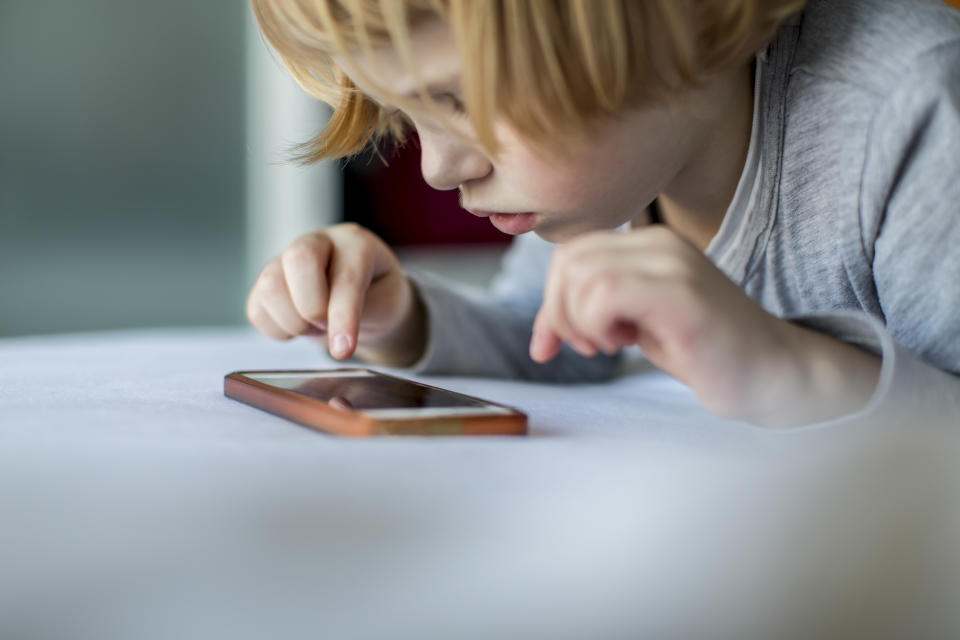 Un niño pequeño juega con el celular.