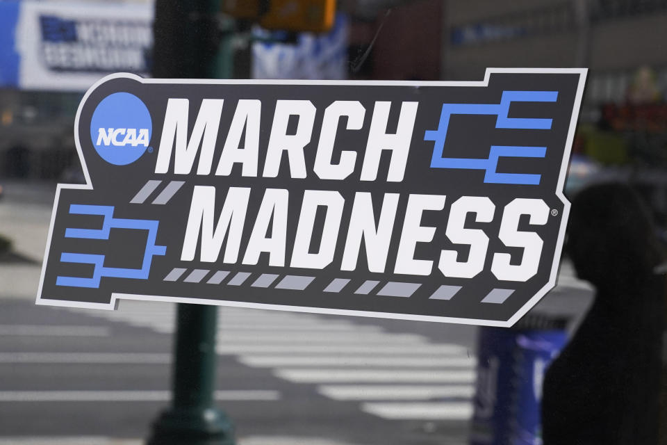 A March Madness sticker for the NCAA college basketball tournament is placed on a window in downtown Indianapolis, Wednesday, March 17, 2021. (AP Photo/Darron Cummings)