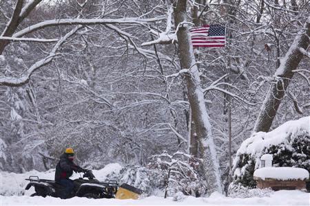 A young man clears a driveway on his all-terrain vehicle (ATV), as a winter storm moves across the midwest, in Milwaukee, Wisconsin December, 22, 2013. REUTERS/Darren Hauck