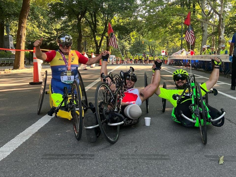 Roman Leykin poses with two other adaptive athletes