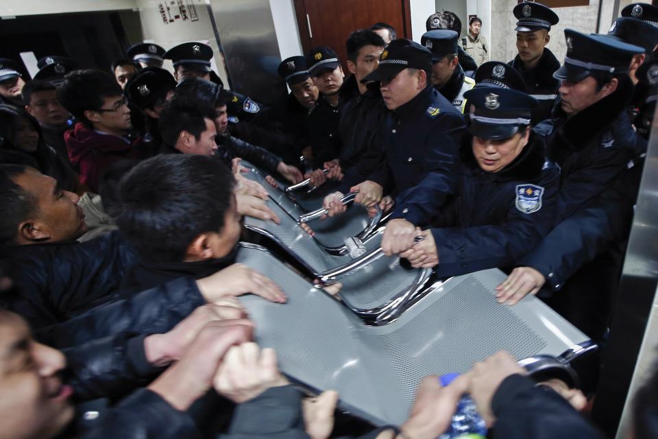 People clash with police as they try to visit relatives injured in a stampede, at a hospital in central Shanghai