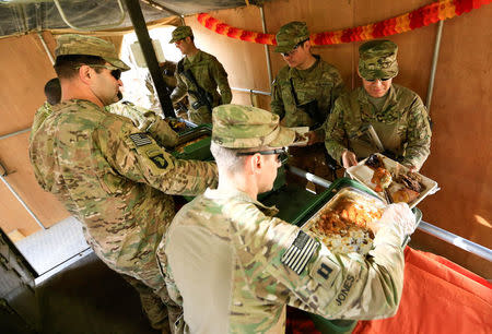 U.S. soldiers serve food to fellow soldiers as they celebrate Thanksgiving Day inside the U.S. army base in Qayyara, south of Mosul, Iraq November 24, 2016. REUTERS/Thaier Al-Sudani