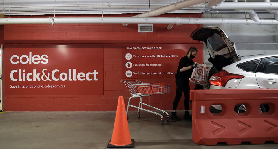 A worker loads a Coles Click and Collect order into a car boot. Source: Getty Images