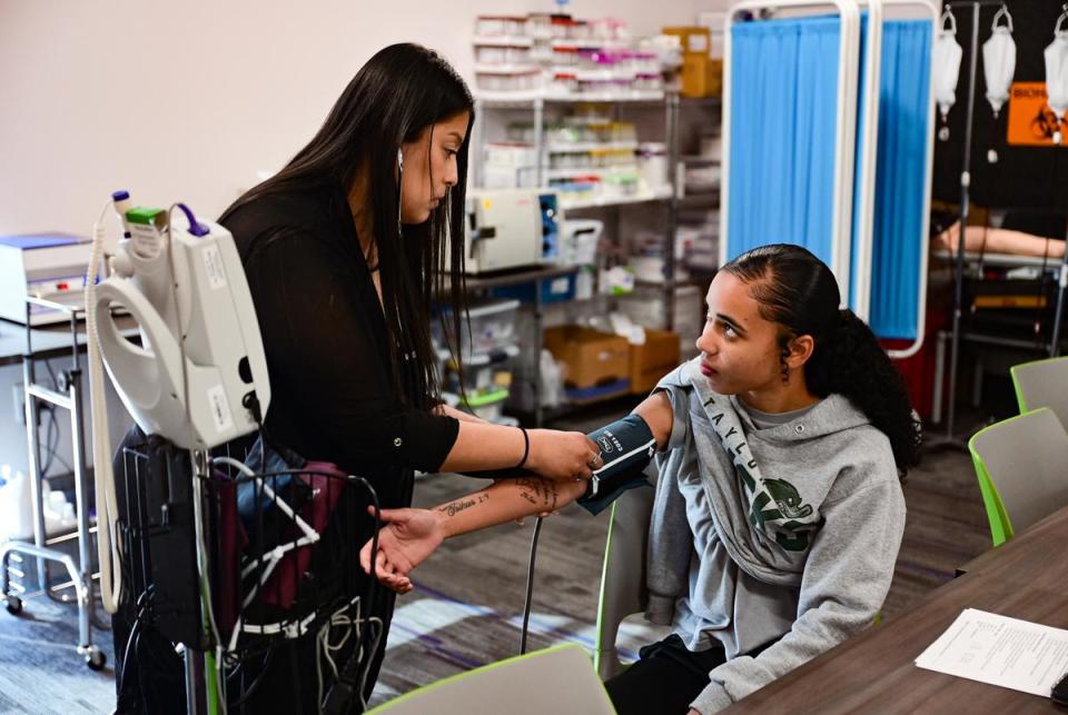 Nora Hernandez-Mondragon measures 21-year-old Violet Fields’ blood pressure during class at the Leander Campus of Austin Community College on Oct. 4. The students were participating in a healthcare apprenticeship program for Baylor Scott & White employees.