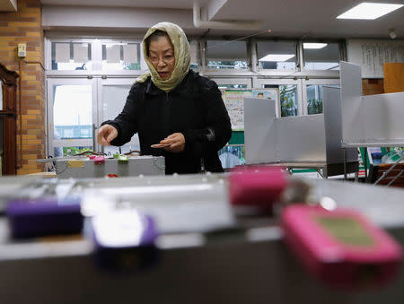 A woman casts her ballot for a national election at a polling station in Tokyo, Japan October 22, 2017. REUTERS/Kim Kyung-Hoon