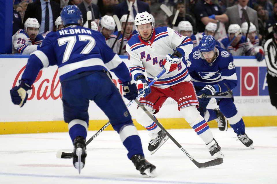 New York Rangers left wing Artemi Panarin (10) carries the puck between Tampa Bay Lightning defenseman Victor Hedman (77) and center Tyler Motte (64) during the first period of an NHL hockey game Saturday, Dec. 30, 2023, in Tampa, Fla. (AP Photo/Chris O'Meara)