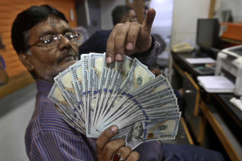 A Pakistani money trader checks U.S. 100 dollar notes at a currency exchange office, in Karachi, Pakistan, Thursday, May 19, 2022. Pakistan’s currency has plummeted to an all-time record low in intraday trading against the U.S. dollar amid uncertainty about the success of crucial talks between the International Monetary Fund and the government of Prime Minister Shahbaz Sharif, which is considering massive new taxation to avoid a default. (AP Photo/Fareed Khan)