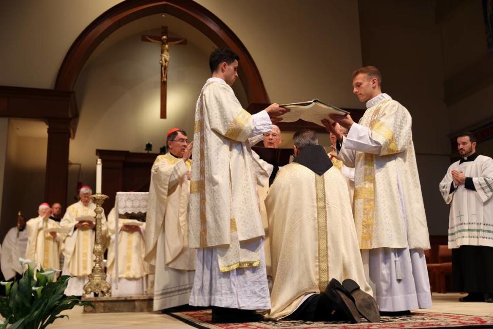 The Book of the Gospels is held by two deacons over the head of Bishop-elect Michael T. Martin during a prayer of ordination at Saint Mark Catholic Church in Huntersville on May 29, 2024.