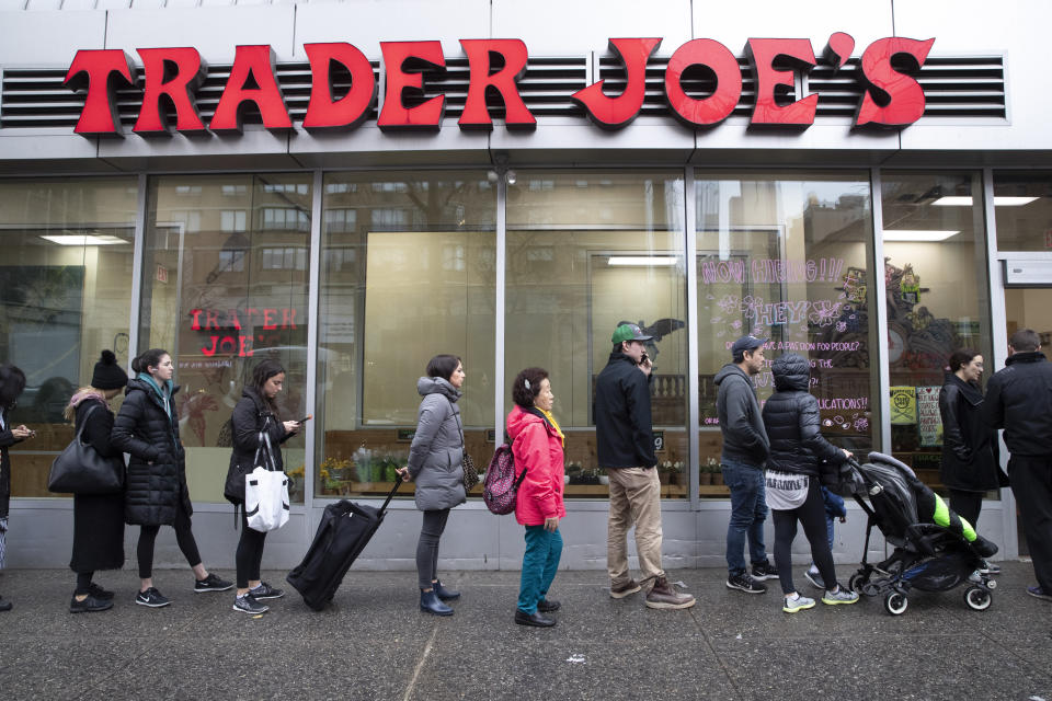 Customers line up to enter a Trader Joe's grocery story, Friday, March 13, 2020, in New York.  (AP Photo/Mary Altaffer)