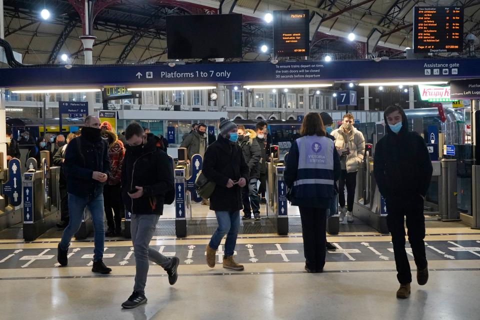 Commuters wearing masks because of the Covid-19 pandemic are seen at London's Victoria Station during the morning rush hour on December 21, 2020 after London was placed under stringent Tier 4 coronavirus restrictions as cases of the virus surge due to a new more infectious strain. - The British prime minister was to chair a crisis meeting on December 21 as a growing number of countries blocked flights from Britain over a new highly infectious coronavirus strain the UK said was "out of control". (Photo by Niklas HALLE'N / AFP) (Photo by NIKLAS HALLE'N/AFP via Getty Images)