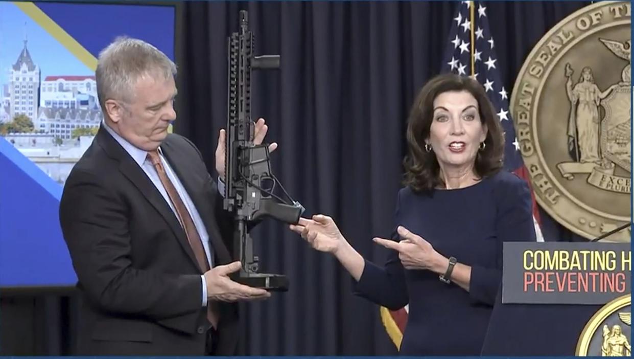 In this image taken from video, Kevin Bruen, Superintendent of the New York State Police, holds a firearm as New York Gov. Kathy Hochul speaks during a news conference, Wednesday, May 18, 2022, in New York. 