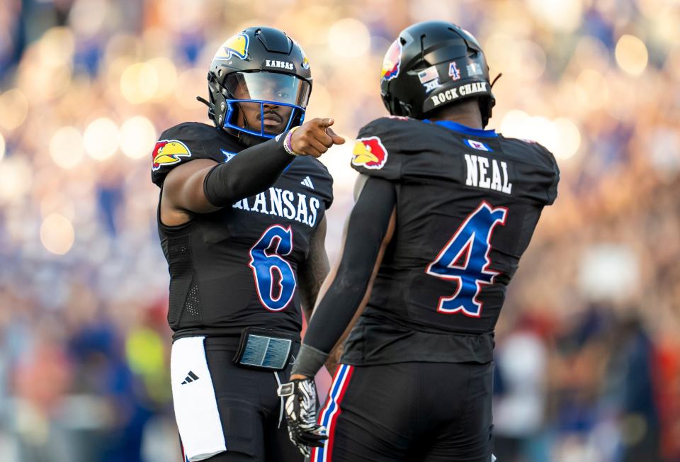 Kansas quarterback Jalon Daniels (6) celebrates with running back Devin Neal (4) on Friday after a touchdown against the Illinois Fighting Illini during the first half of a game in Lawrence at David Booth Kansas Memorial Stadium.