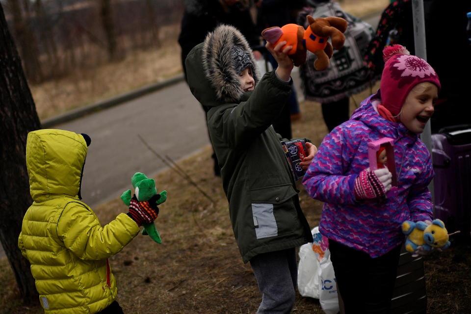 Children play with toys that charity workers gave them after fleeing from Ukraine to Romania, amid Russia's invasion of Ukraine, at the border crossing in Siret, Romania, March 16, 2022. REUTERS/Clodagh Kilcoyne