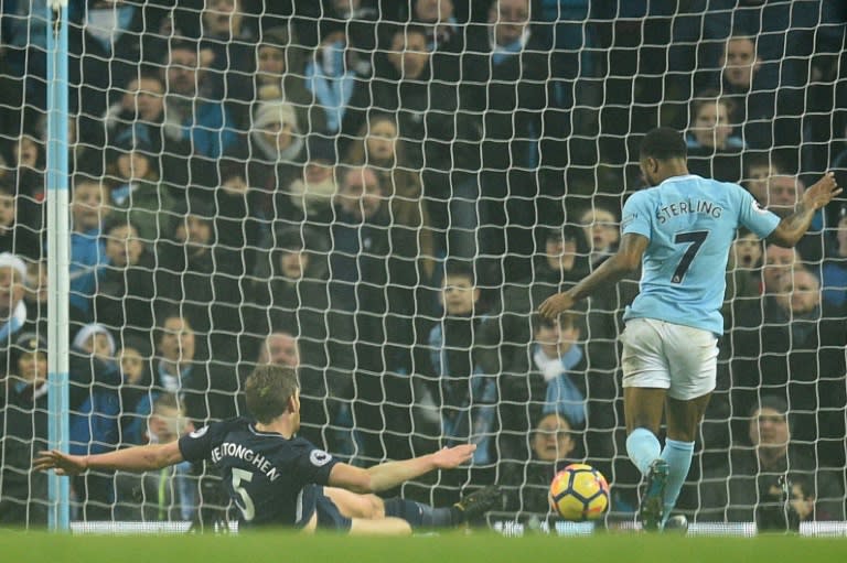 Manchester City's Raheem Sterling (R) scores their third goal past Tottenham Hotspur's Jan Vertonghen