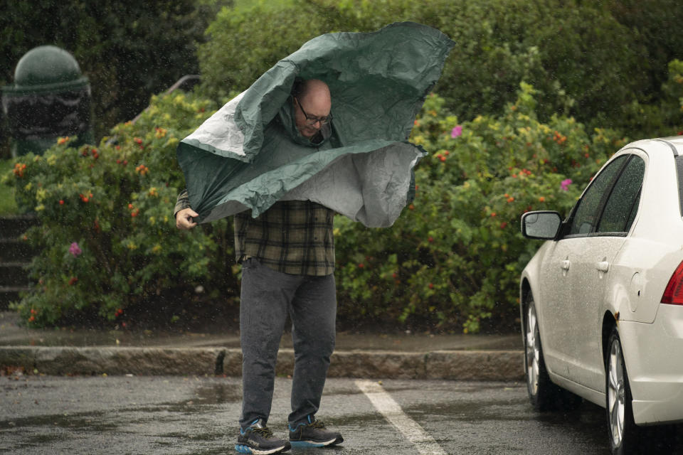 Un turista lidia con los fuertes vientos a la llegada de la tormenta Lee a la región, el sábado 16 de septiembre de 2023, en Bar Harbor, Maine, (AP Foto/Robert F. Bukaty)