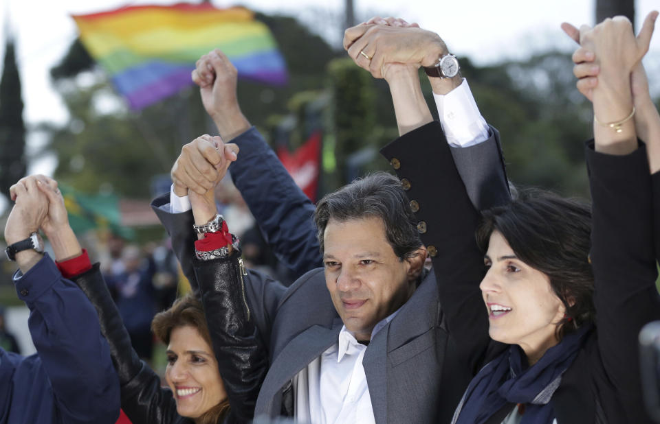 <p>Der Kandidat der brasilianischen Arbeiterpartei, Fernando Haddad (Mitte), und seine Stellvertreterin Manuela d’Ávila (rechts) bei einer Wahlkampfveranstaltung vor dem Hauptgebäude der Polizei. Seit Dienstag ist dort der ehemalige Präsident Lula da Silva wegen Korruptionsvorwürfen inhaftiert. (Bild: AP Photo/Eraldo Peres) </p>