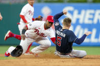 Philadelphia Phillies shortstop Jean Segura, left, tags out Atlanta Braves' Freddie Freeman, right, who was trying to steal second base during the third inning of a baseball game, Friday, July 23, 2021, in Philadelphia. (AP Photo/Chris Szagola)