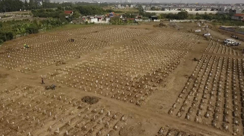 In this image from drone video, rows of burial plots are lined up at the Rorotan cemetery, a graveyard built for COVID-19 victims in Jakarta, Indonesia on July 23, 2021. Indonesia surpassed the grim milestone of 100,000 official COVID-19 deaths on Wednesday, Aug. 4, 2021, as the country struggles with its worst pandemic year fueled by the delta variant, with growing concerns that the actual figure could be much higher with people also dying at home. (AP Photo/Andi Jatmiko)