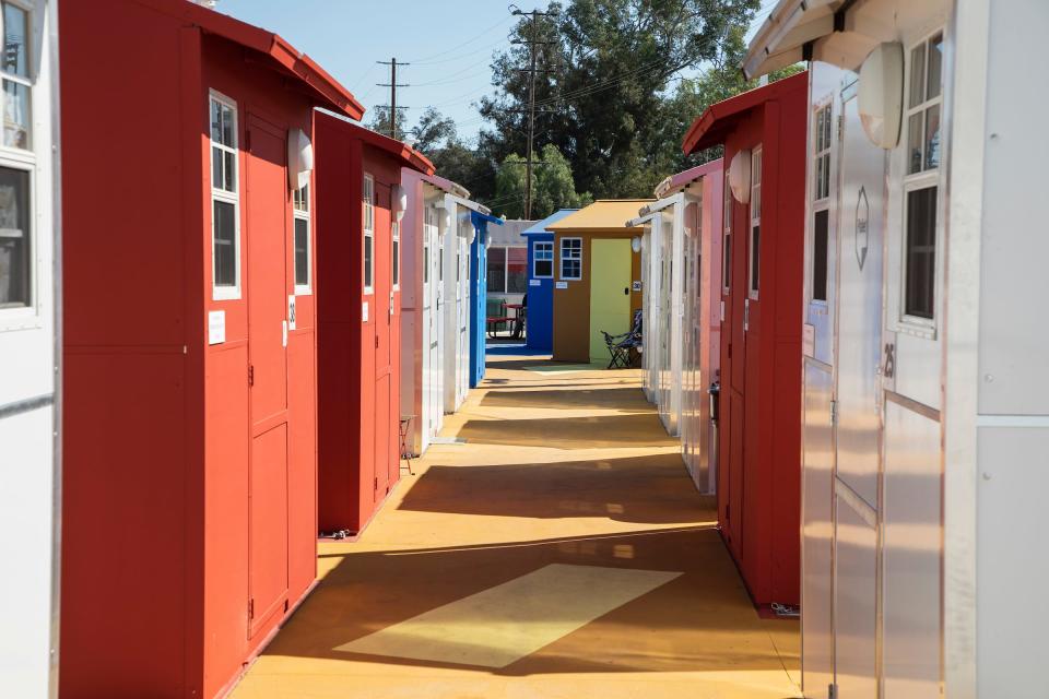 The walkway between tiny homes, painted red, white, and blue.